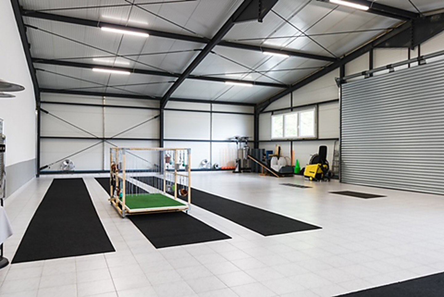 Die helle Trainingshalle der Hundeschule Spessart mit Gummimatten und Trainingsgeräten